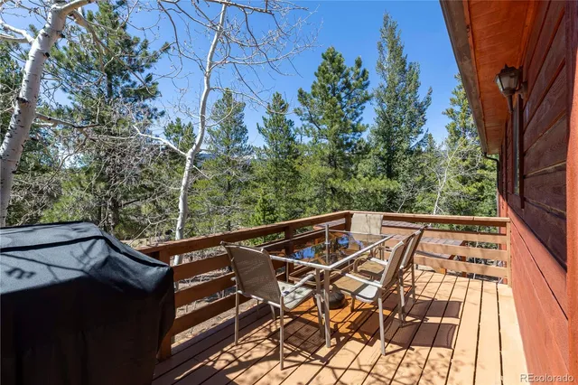 a view of a balcony with chairs and wooden fence