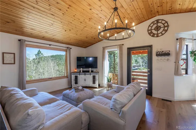 a living room with furniture a large window with kitchen view