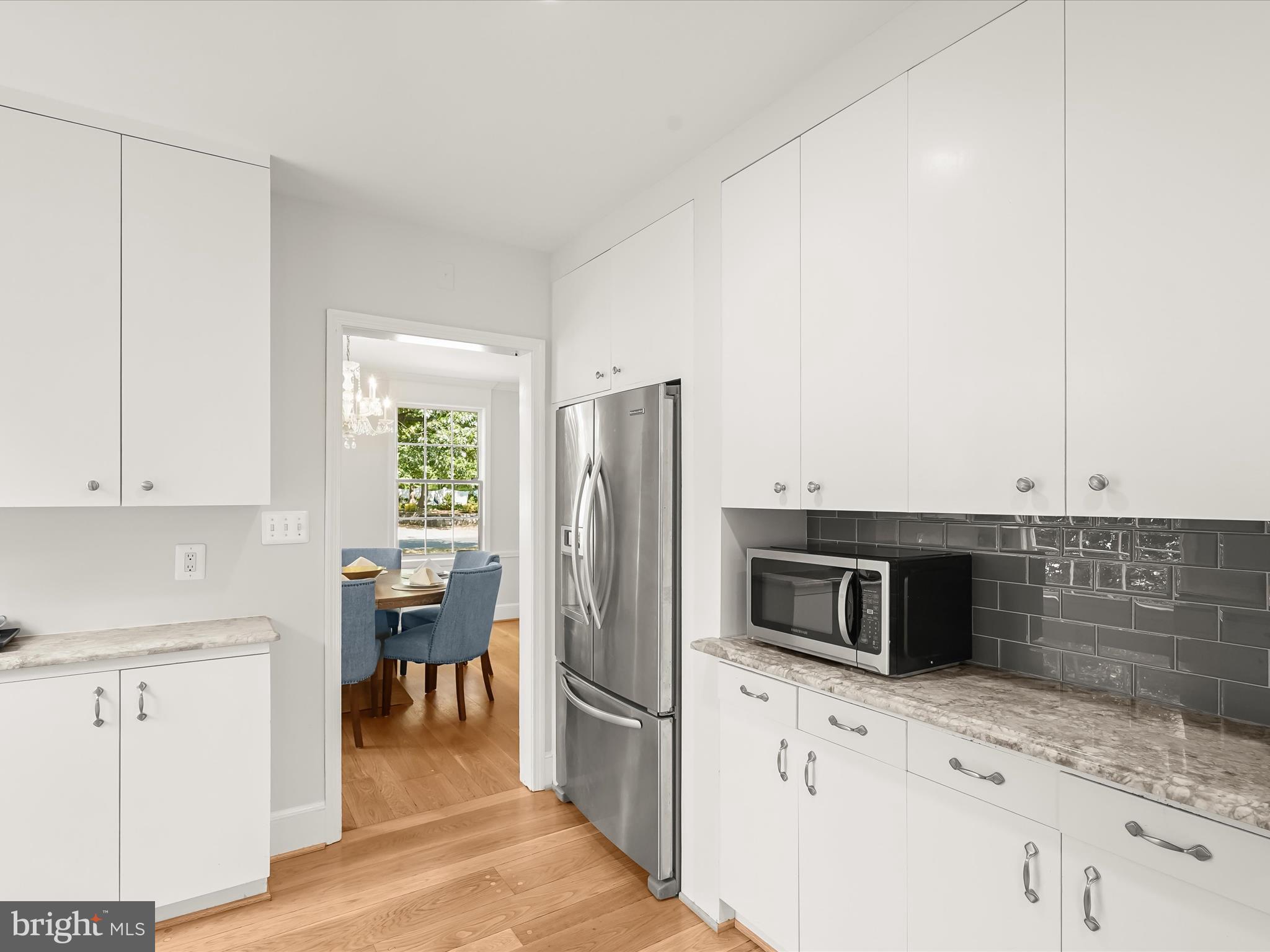 6302 Broad Branch Road Chevy Chase, MD 20815 - Photo 19 of 55 a kitchen with stainless steel appliances white cabinets and wooden floor