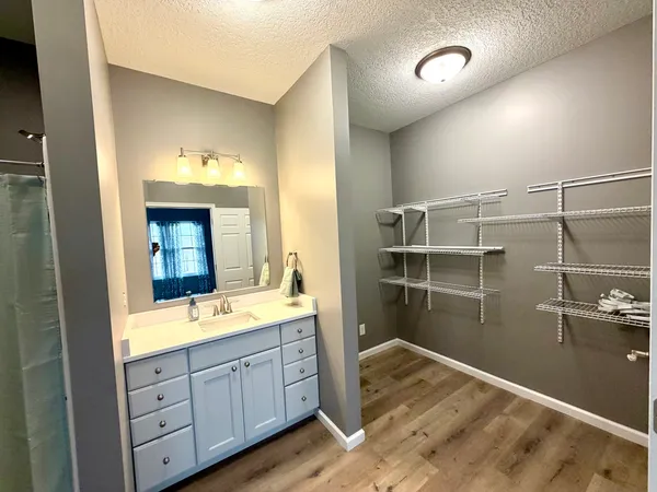 a spacious bathroom with a granite countertop sink and a mirror