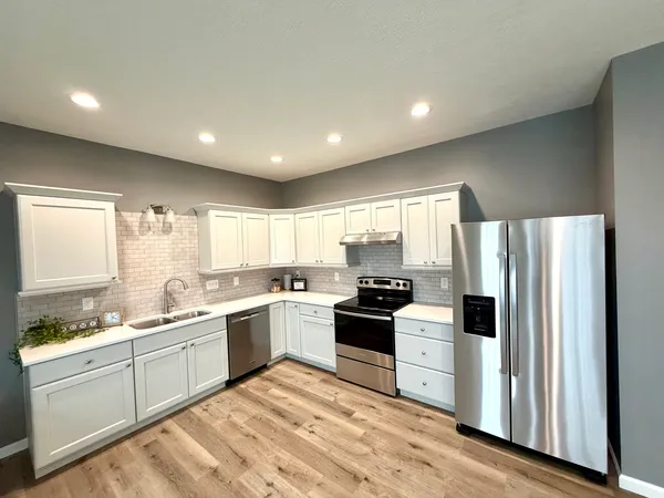 a large kitchen with stainless steel appliances granite countertop a stove a sink and a refrigerator