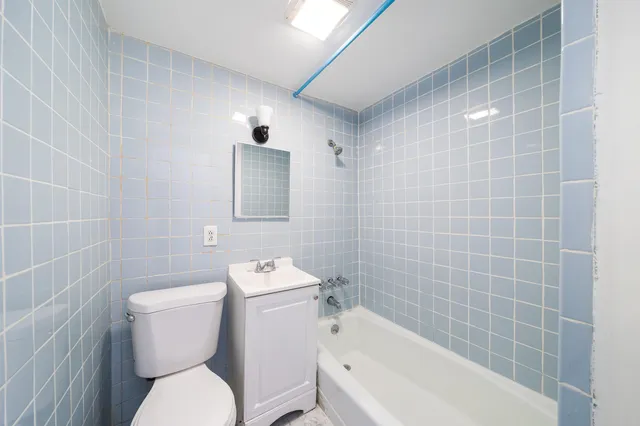 a white toilet sitting next to a white bath tub