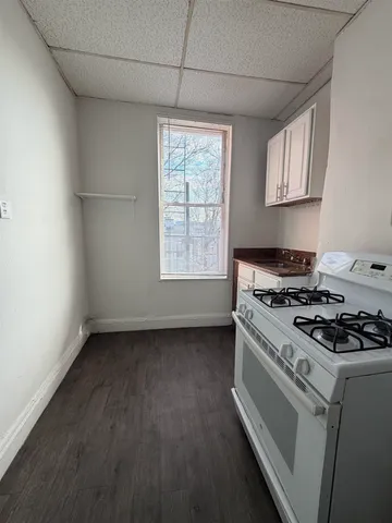 a kitchen with a stove a refrigerator and a stove top oven