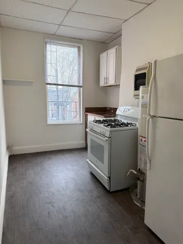 a view of a refrigerator in kitchen and wooden floor