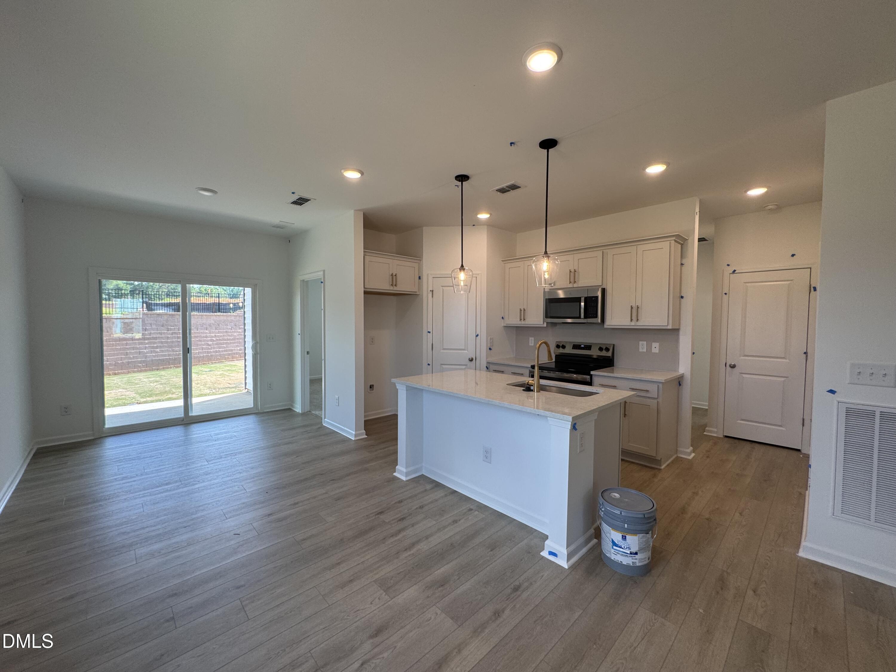 11754 Salers Loop Middlesex, NC 27557 - Photo 6 of 21 a kitchen with stainless steel appliances kitchen island granite countertop a stove a refrigerator a sink a microwave oven with wooden floor and cabinets