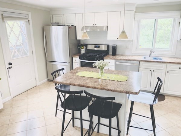 6 Saugus Avenue, Unit A Saugus, MA 01906 - Photo 10 of 26 a kitchen with stainless steel appliances granite countertop a stove a refrigerator a sink a dining table and chairs