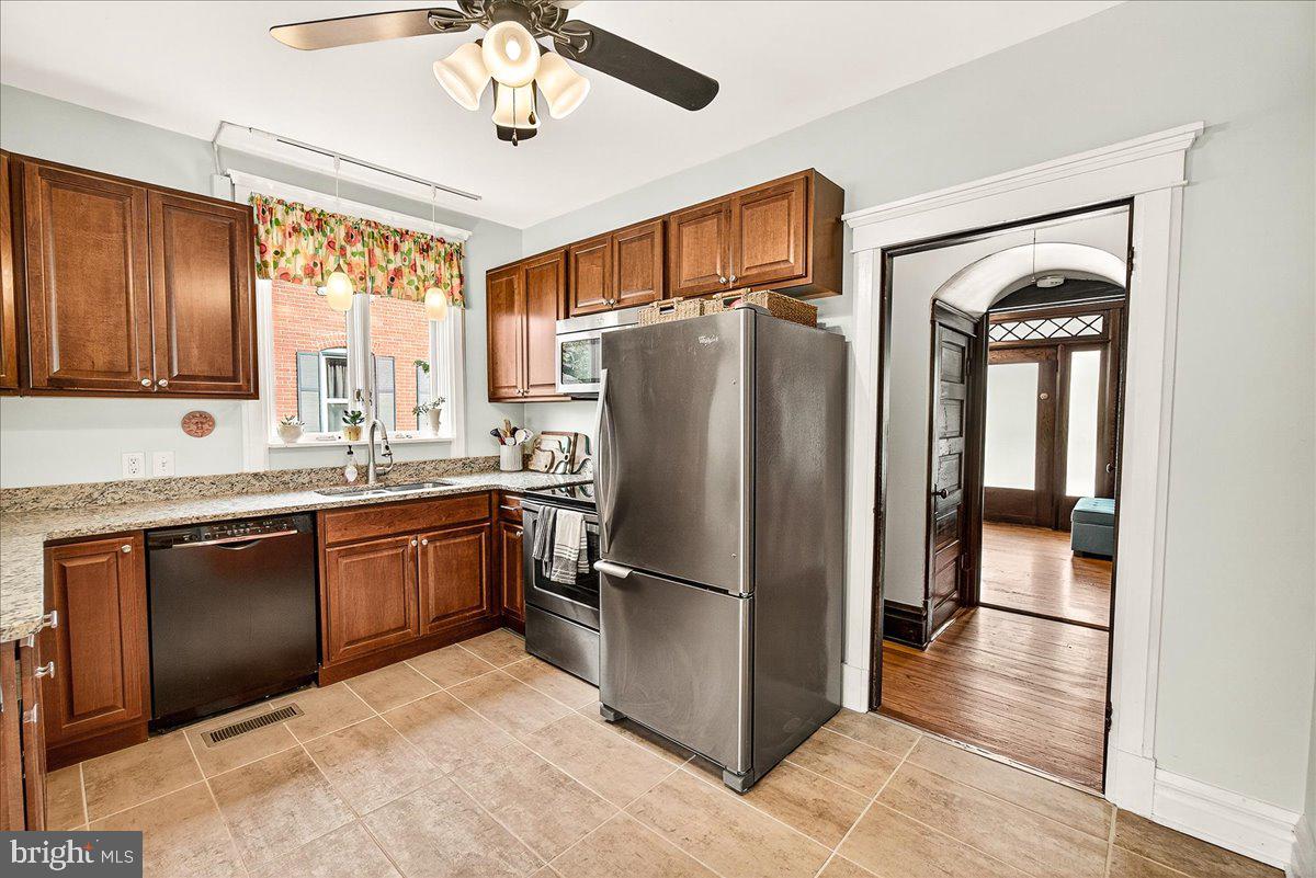 144 South Main Street Boonsboro, MD 21713 - Photo 12 of 48 a kitchen with stainless steel appliances granite countertop a refrigerator a stove and a sink with wooden floors