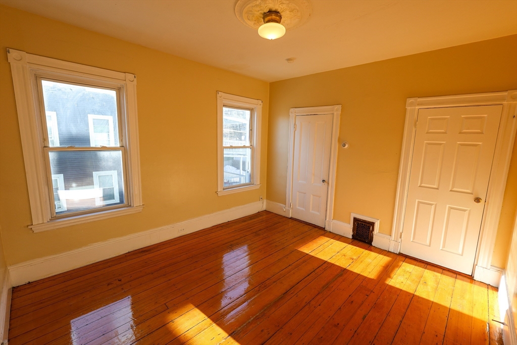35 Clarkson Street, Unit 2 Boston, MA 02125 - Photo 6 of 9 a view of an empty room with wooden floor and a window