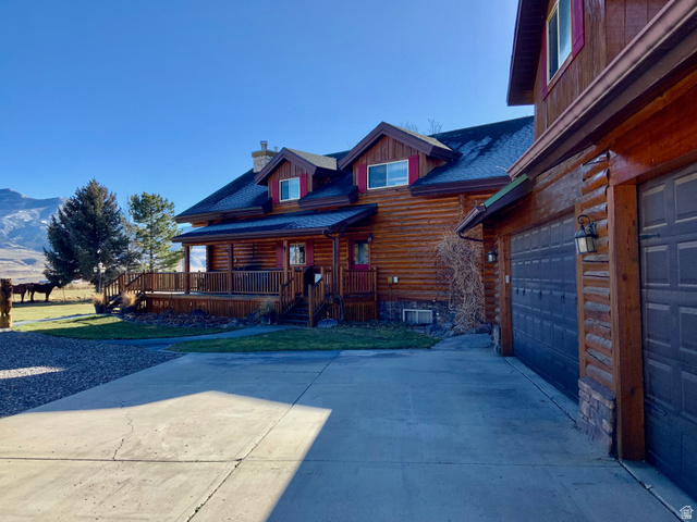 76 Highway 118 Monroe, UT 84754 - Photo 20 of 76 View of front of house featuring a shingled roof, a chimney, concrete driveway, a porch, and log siding