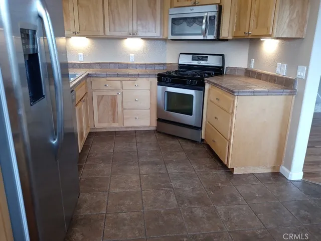 a kitchen with stainless steel appliances granite countertop a stove a refrigerator and a cabinets