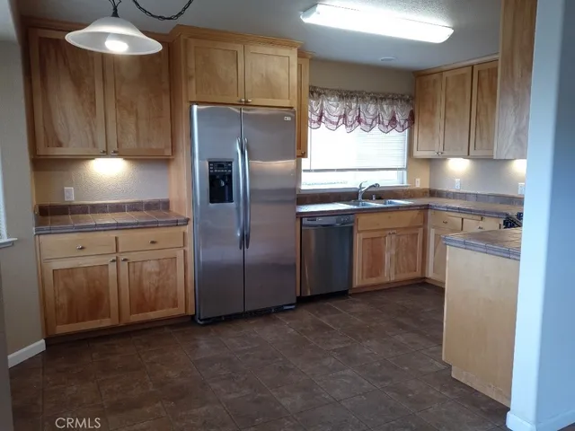 a kitchen with stainless steel appliances granite countertop a refrigerator sink and cabinets