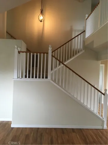 a view of staircase with railing and white walls