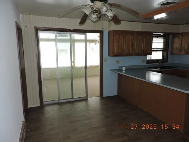 a kitchen with stainless steel appliances granite countertop a sink a counter space and a window