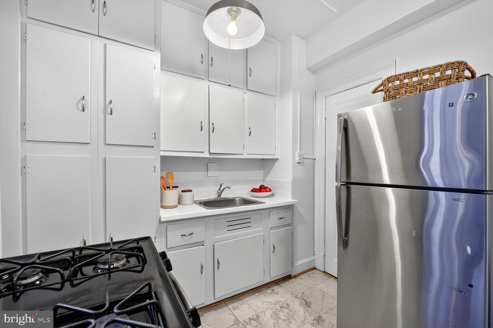 2707 Adams Mill Road Northwest, Unit 303 Washington, DC 20009 - Photo 19 of 27 a kitchen with stainless steel appliances a refrigerator sink and cabinets