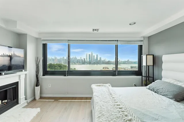 a bedroom with a bed and a large window with outer view