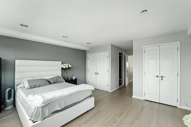 a bedroom with a bed and wooden floor