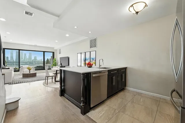 a kitchen with stainless steel appliances granite countertop a lot of cabinets and couches