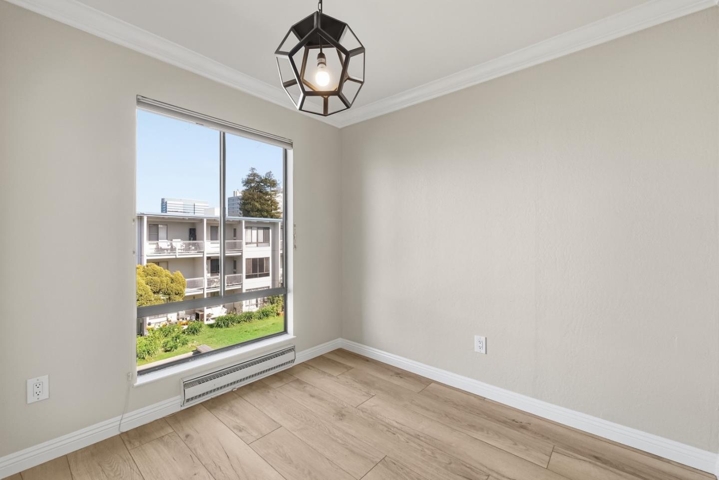8 Commodore Drive, Unit C457 Emeryville, CA 94608 - Photo 9 of 48 an empty room with wooden floor exposed radiator and windows