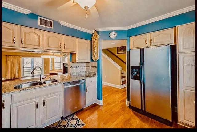 a kitchen with stainless steel appliances a refrigerator sink and cabinets