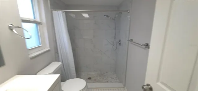 a bathroom with a toilet and a shower
