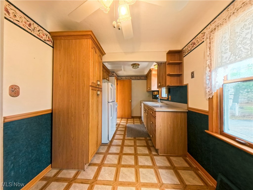 1668 Harwich Road Cleveland, OH 44124 - Photo 5 of 19 Kitchen with wainscoting, brown cabinetry, light countertops, inlaid floor details, and open shelves