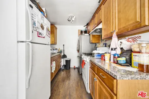 a kitchen with stainless steel appliances granite countertop a refrigerator and a stove