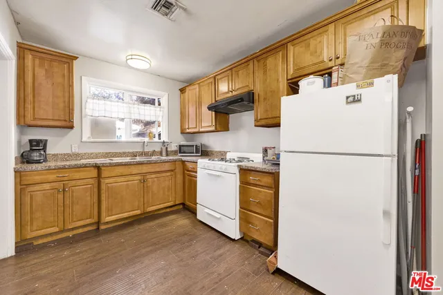 a kitchen with sink cabinets and white appliances