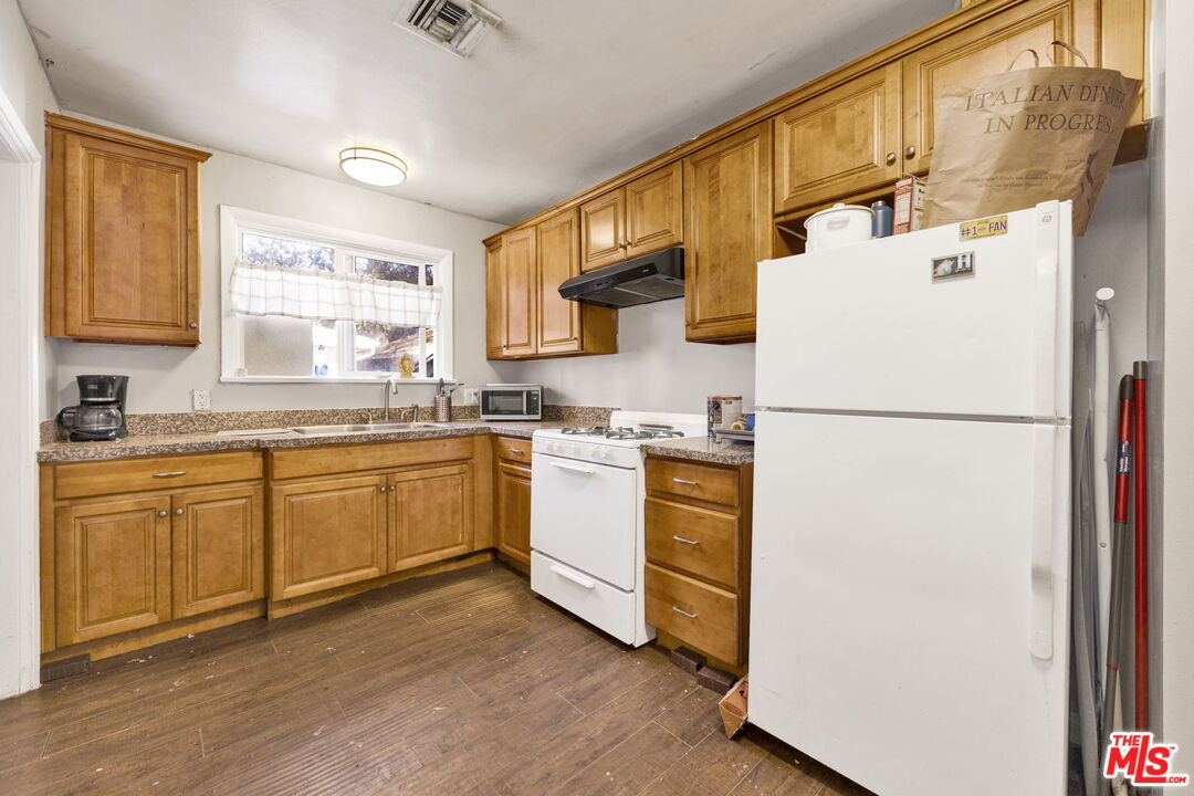14541 Hart Street Van Nuys, CA 91405 - Photo 10 of 39 a kitchen with sink cabinets and white appliances