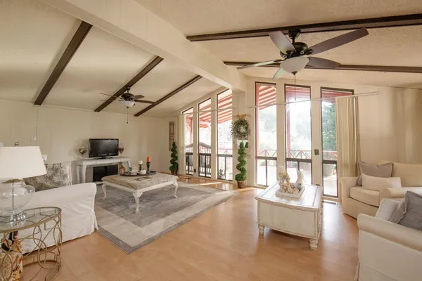 a dining hall with couches a flat tv screen and a dining table with wooden floor