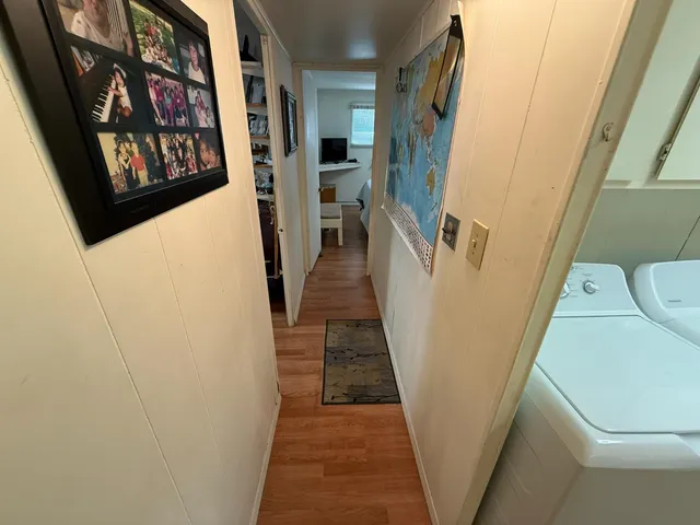 a view of a hallway with wooden floor and stairs