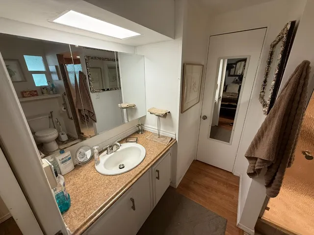 a bathroom with a granite countertop sink and a mirror