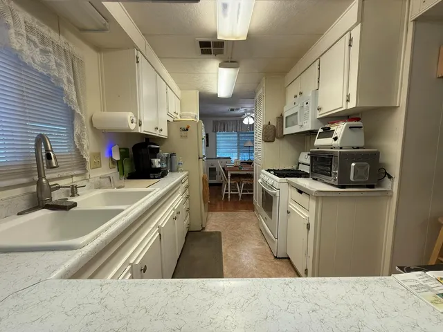 a kitchen with stainless steel appliances granite countertop a sink a stove and a refrigerator