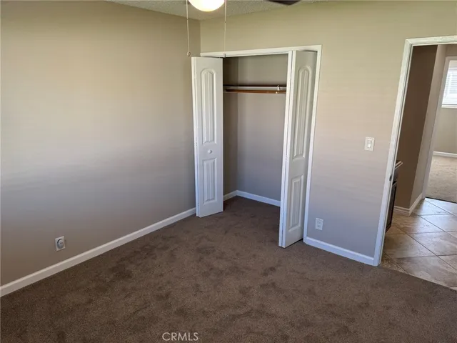 an empty room with closet and a hallway
