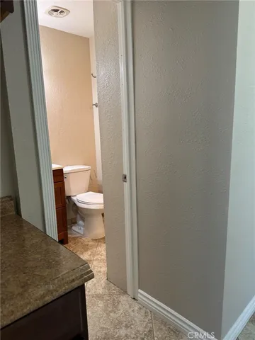 a bathroom with a granite countertop toilet and a sink