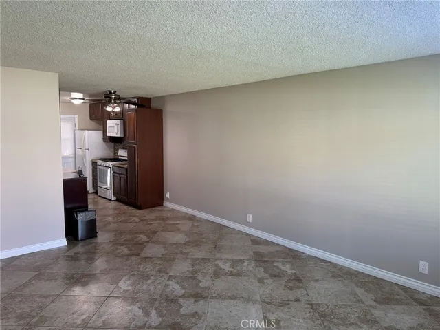 a view of a kitchen with a stove fridge and wooden floor