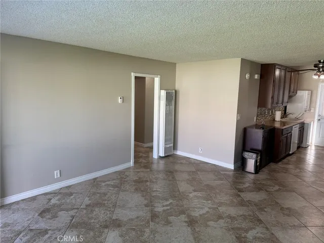 a view of a kitchen with furniture and stainless steel appliances