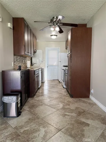 a kitchen with stainless steel appliances granite countertop a refrigerator a stove and a sink