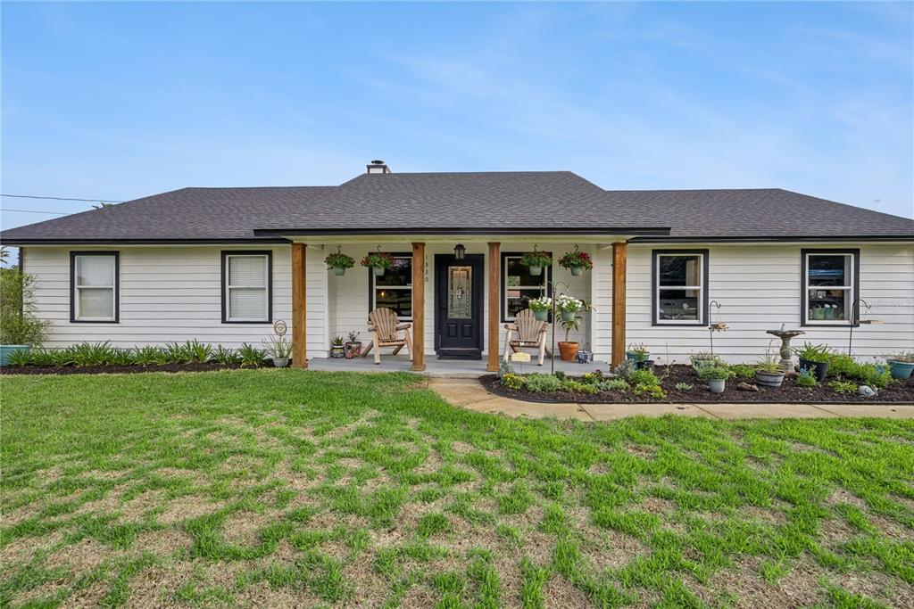 1330 Lake Mills Road Chuluota, FL 32766 - Photo 1 of 59 a front view of a house with a garden and yard