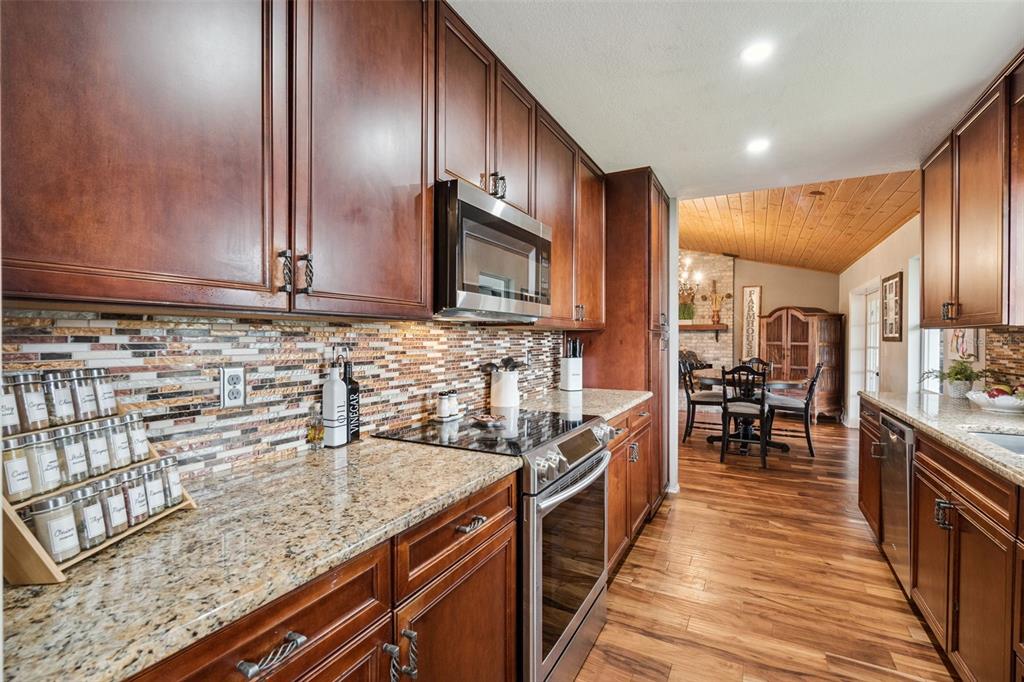 1330 Lake Mills Road Chuluota, FL 32766 - Photo 15 of 59 a kitchen with stainless steel appliances granite countertop a stove a sink and a microwave