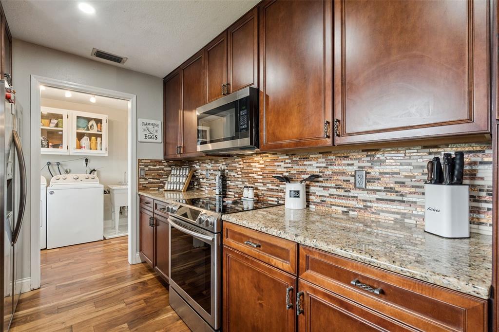 1330 Lake Mills Road Chuluota, FL 32766 - Photo 19 of 59 a kitchen with stainless steel appliances granite countertop a sink stove and microwave
