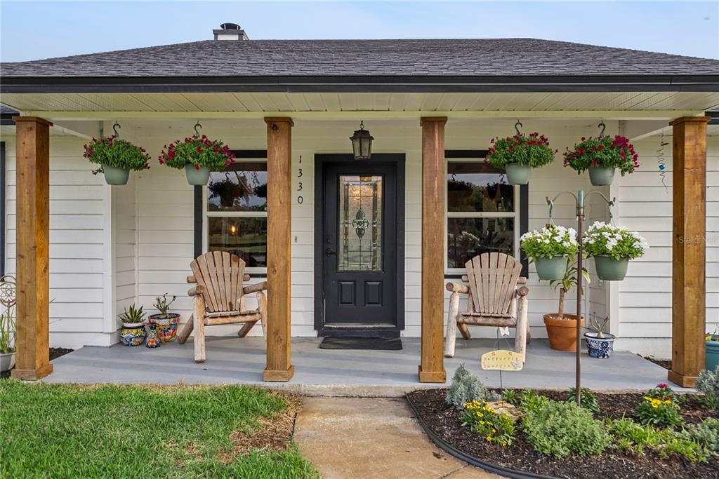 1330 Lake Mills Road Chuluota, FL 32766 - Photo 2 of 59 a front view of a house with a garden and plants