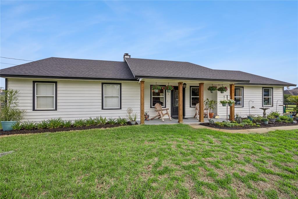 1330 Lake Mills Road Chuluota, FL 32766 - Photo 4 of 59 a front view of a house with a garden and patio