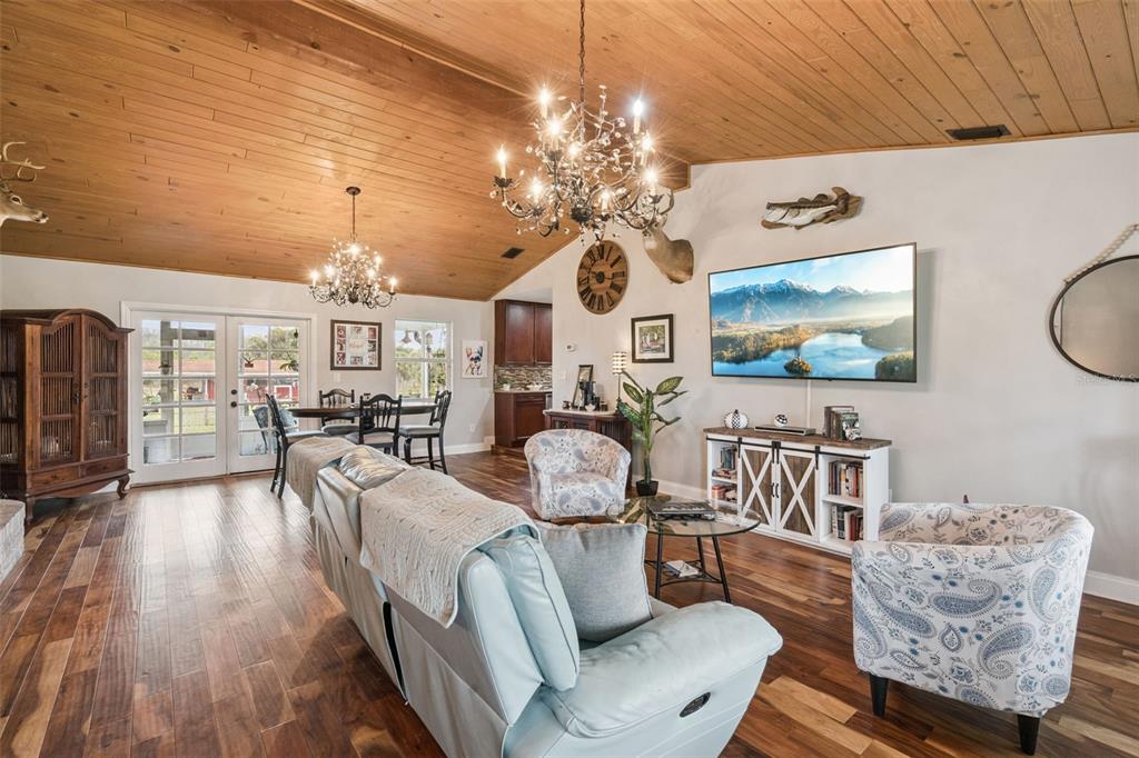 1330 Lake Mills Road Chuluota, FL 32766 - Photo 9 of 59 a living room with furniture a chandelier and a flat screen tv