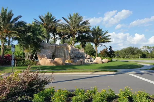 a view of a house with a big yard and palm trees