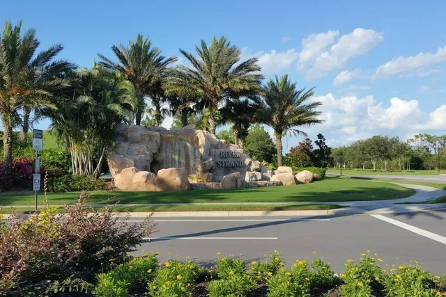 a view of a house with a big yard and palm trees