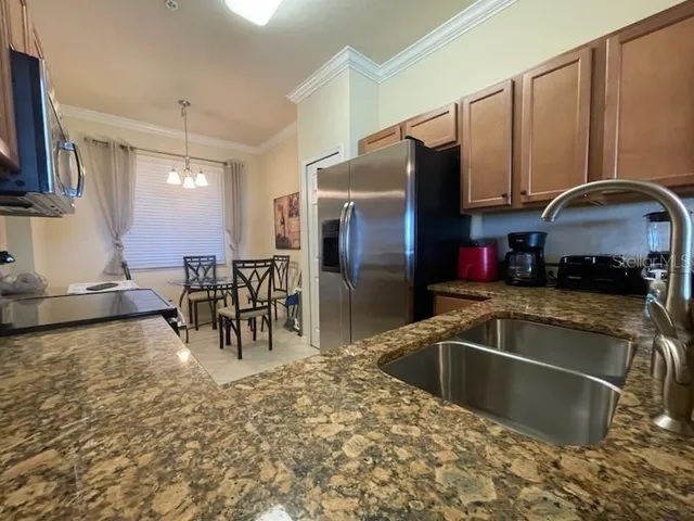 a kitchen with granite countertop a sink and a stove top oven