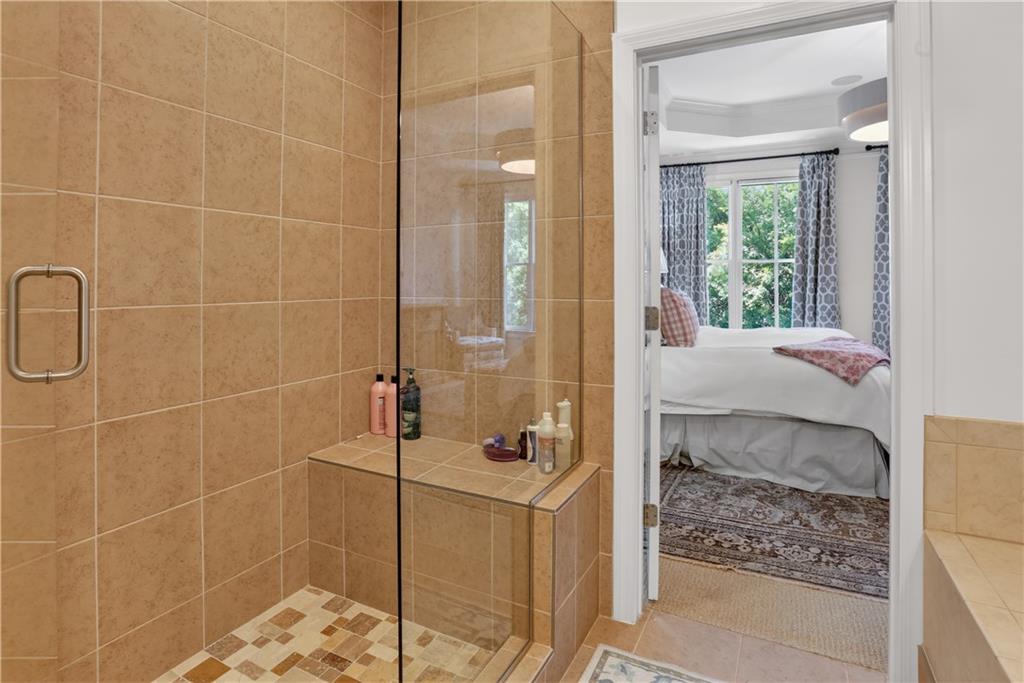 3552 Roswell Road Northwest Atlanta, GA 30305 - Photo 18 of 32 a bathroom with a granite countertop shower a sink and a mirror