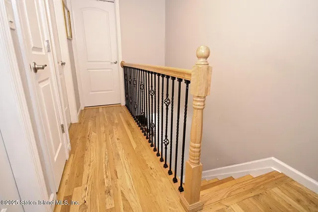 a view of a hallway with wooden floor and cabinet