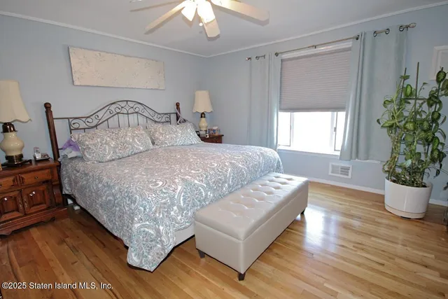 a bedroom with a large bed and a potted plant