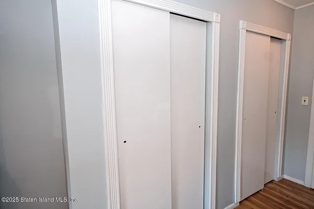 a view of a closet with wooden floor